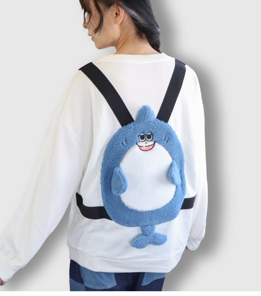 A shark-embroidered fleece sweatshirt in a backpack